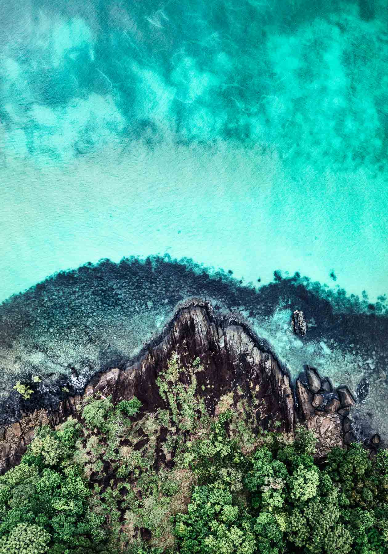 ripples in the ocean as it hits the coastline in this fine art aerial photograph of cape tribulation